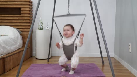 excited little baby jumping in bouncer with lots of joy