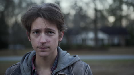 solemn, troubled man stands outside at blue hour, takes deep breaths