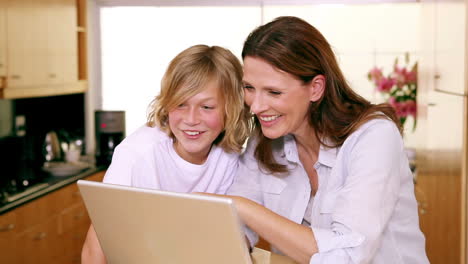 Madre-E-Hijo-Con-Una-Computadora-Portátil-En-La-Cocina