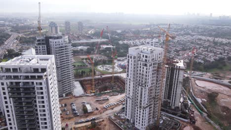 Panoramic-aerial-view-of-skyscrapers-in-construction-with-city-view-in-background,-Tel-Aviv,-Israel