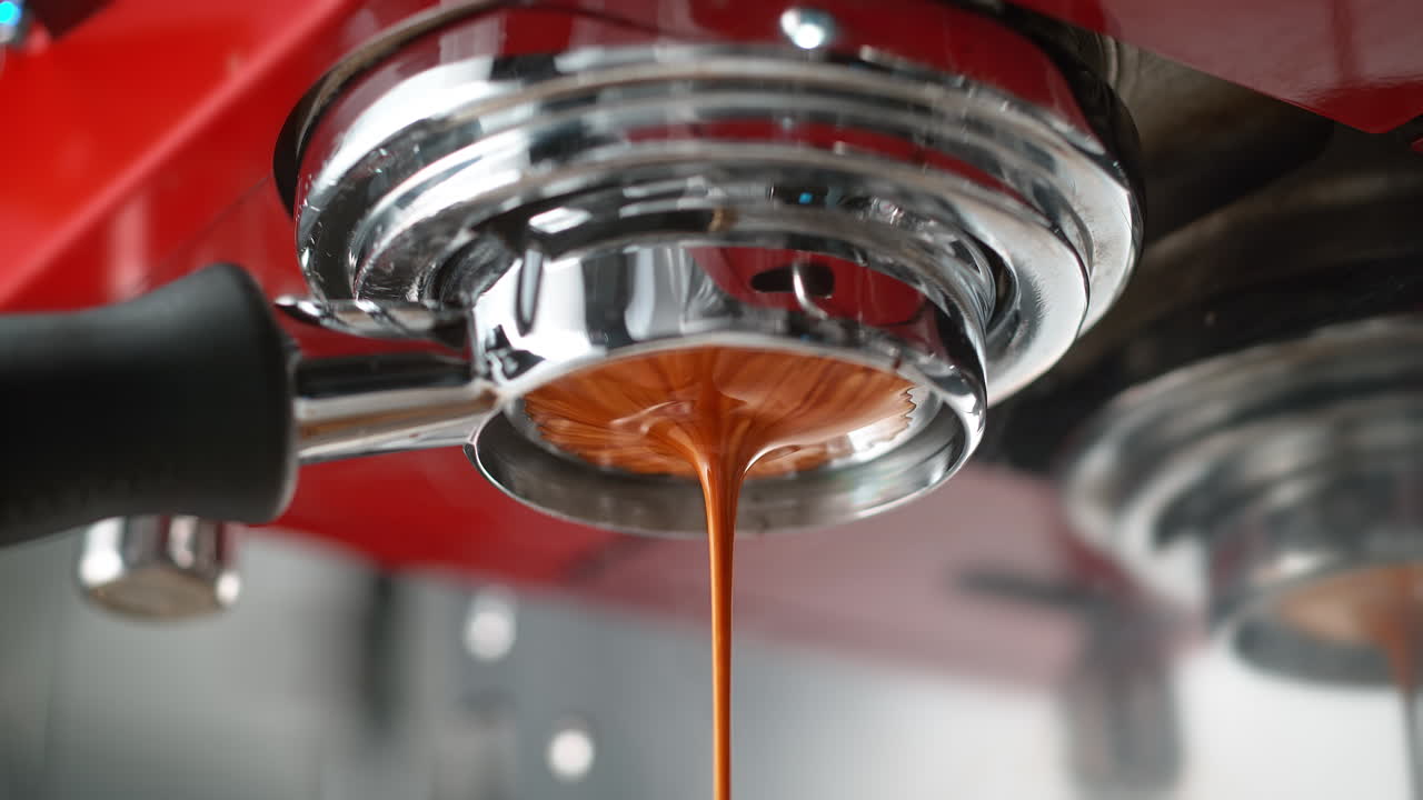 Espresso Extracted Through Bottomless Portafilter In Red Coffee Maker In Macro and Slow Motion