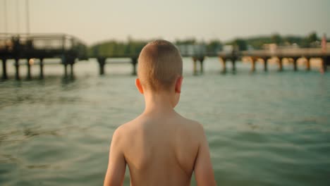 the boy enters the lake, close-up – slow motion