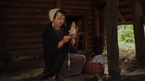 woman spinning wool in a medieval setting