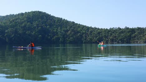 group of kayakers paddling on a calm lake