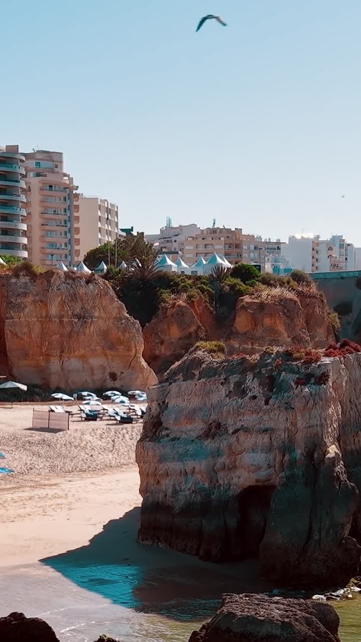Le onde si infrangono sulla riva mentre le persone si godono la spiaggia in Portogallo
