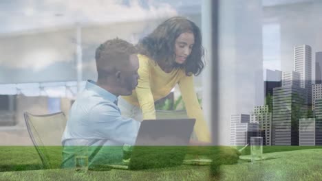 Animation-of-clouds,-low-angle-view-of-grass-and-buildings-on-diverse-coworkers-discussing-in-office