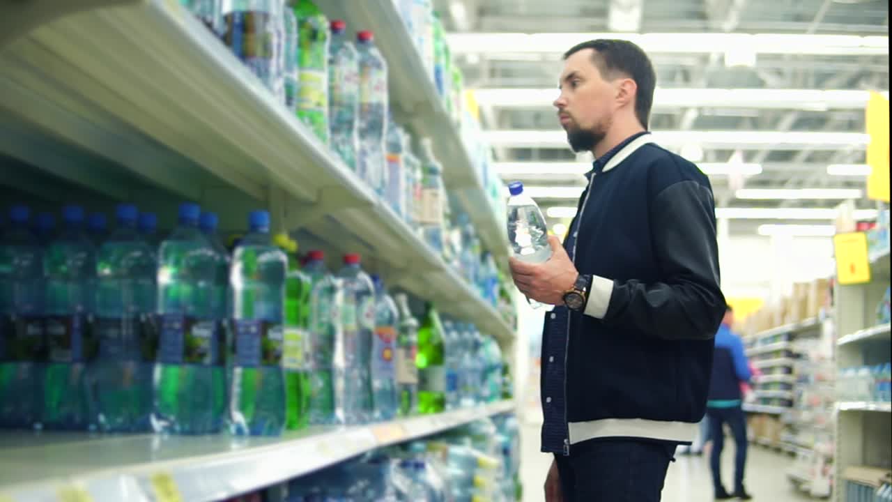 식료품 가게 에서 물 병 을 구입 하는 사람