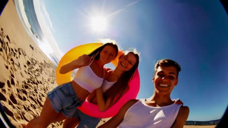 friends enjoying a sunny beach day with inflatable rings