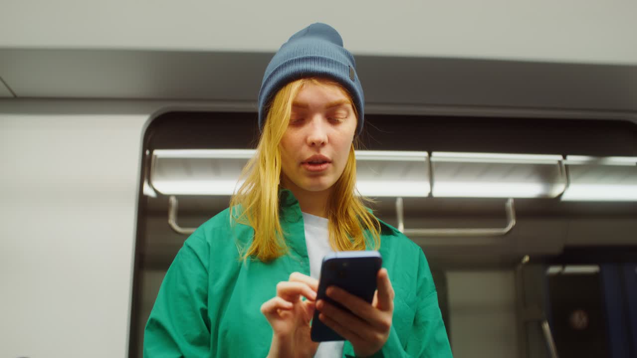 Woman using phone in subway train