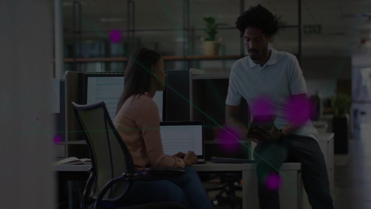Woman gesturing at laptop in office, man leaning and passing stylus while magenta overlay floating