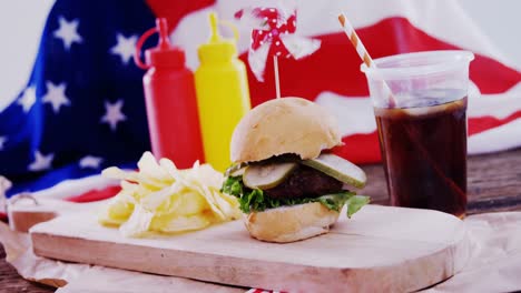 hamburger and cold drink on wooden board