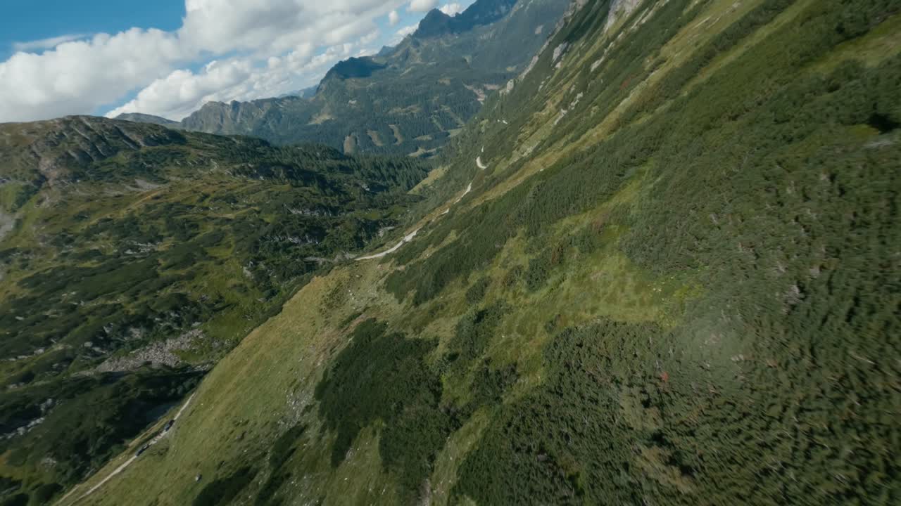 fotografía de un dron fpv, volando sobre las montañas de austria