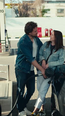 couple filling car at gas station