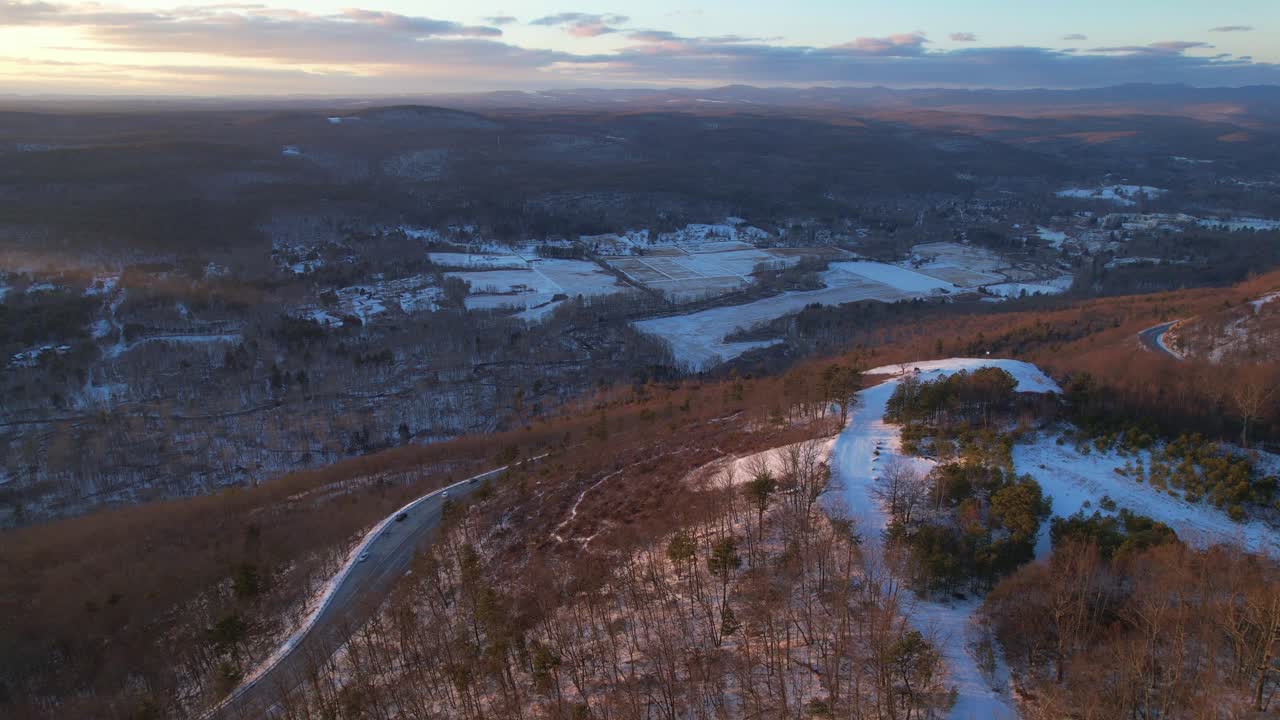 Aerial drone footage of a beautiful, colorful sunset of the snowy Appalachian mountains during winter