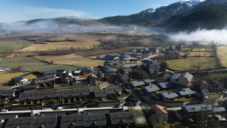 aerial view of the little village of bor in la cerdanya, with the snowy mountains behind