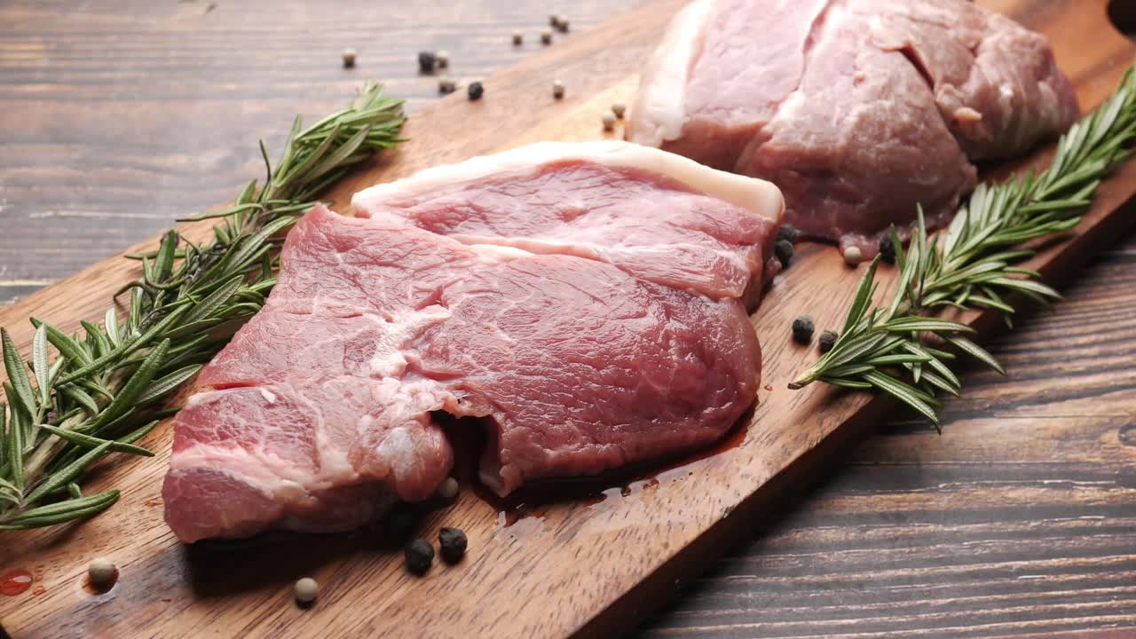 Raw Lamb Chops on Wooden Board with Herbs