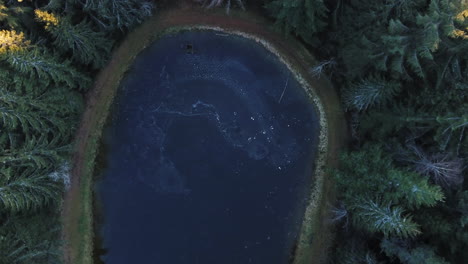 drone shot of a round lake in winter