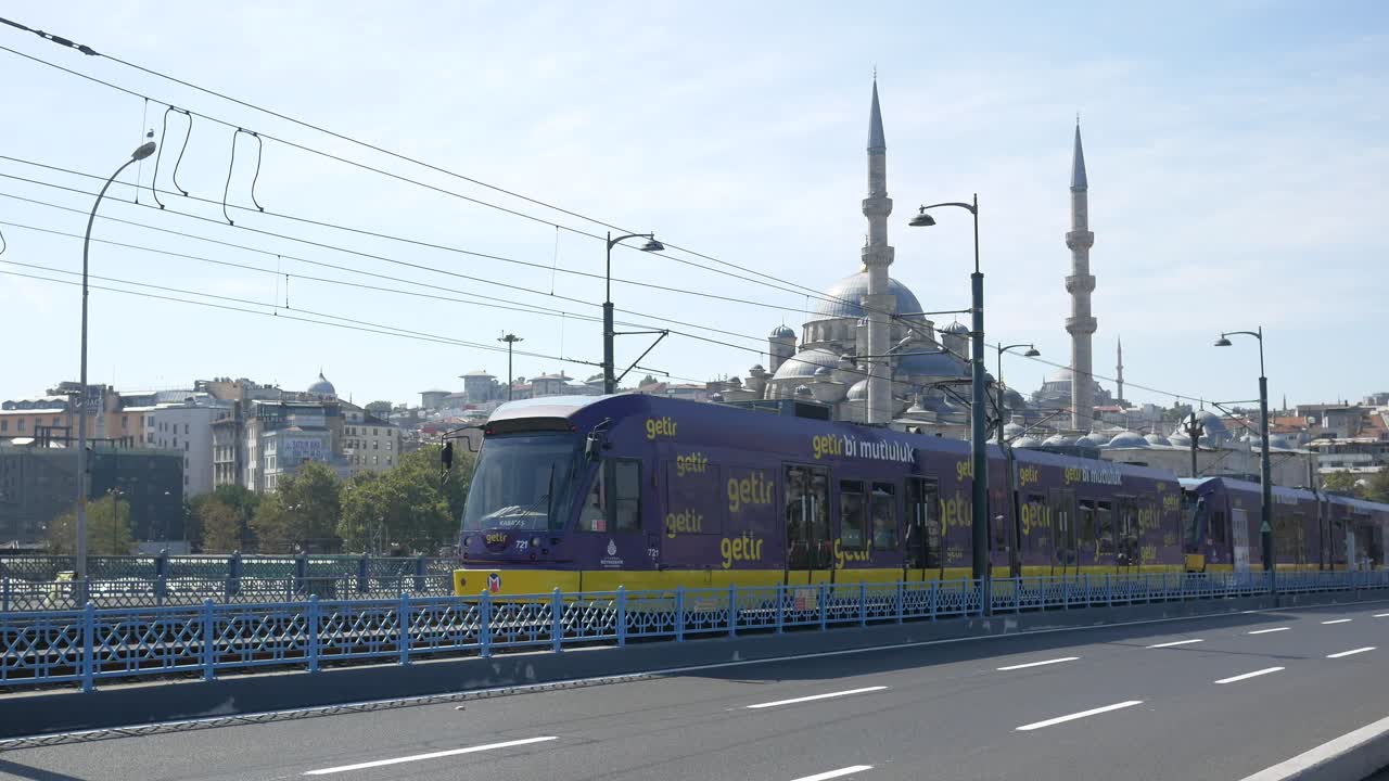 estambul, turquía: una vista de la mezquita azul y un tranvía que cruza el puente galata