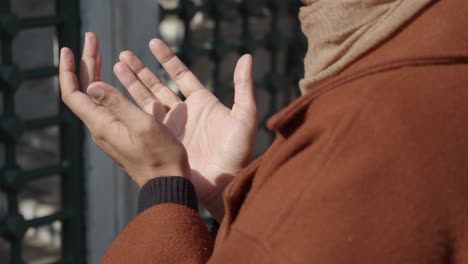 a muslim woman praying with her hands raised