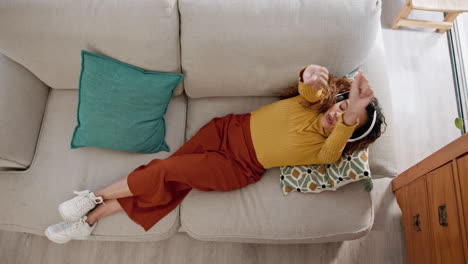 mujer escuchando música en el sofá