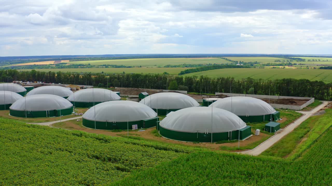 바이오가스를 위한 둥근 저장 크: 녹색 풍경 배경에서 바이오가스 생산, 여름에 에서 현대적인 농업 바이오 농장.