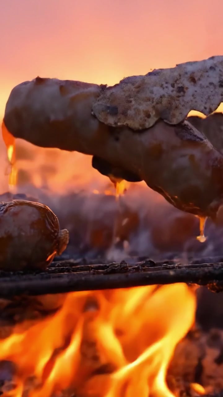 Grigliare salsicce succulente sotto un tramonto infuocato: un'esperienza culinaria che cattura l'essenza della cucina all'aperto in mezzo a un bellissimo bagliore del tramonto.
