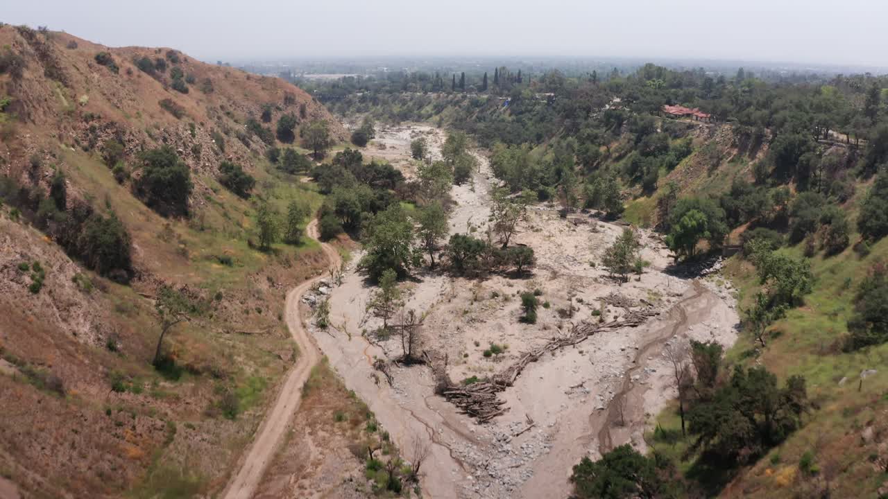 Low aerial tilting up shot of the Eaton Canyon Wash in the burn zone after the Los Angeles Fires in Southern California.