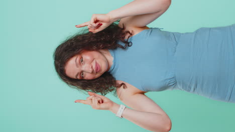 young woman showing thumbs up and pointing overhead on blank space place for advertisement logo