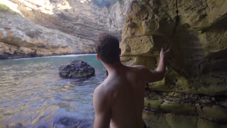 sporty young man walking in the seaside cave.