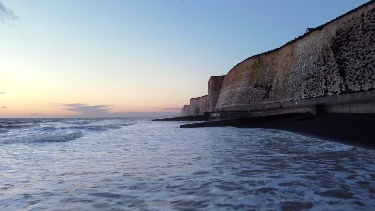 hermosa puesta de sol en la costa de brighton con olas de mar y playa en inglaterra