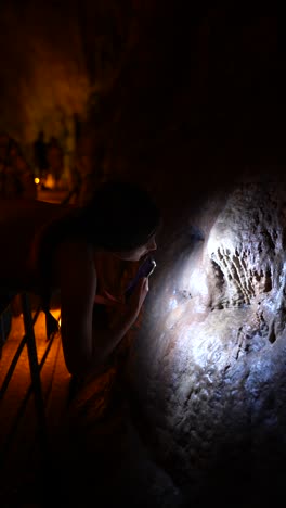 woman taking a picture of cave formations