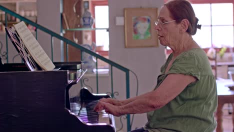 anciana tocando un piano de cola en su casa