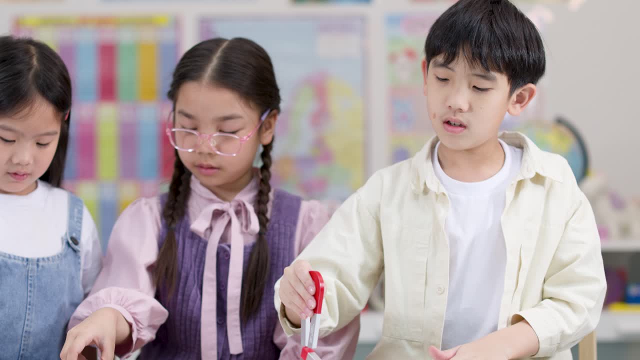 好奇心旺盛な小学生たちが、カラフルな教室で磁石を使った実践的な実験に協力している様子を、安定したミディアムショットで捉えました。