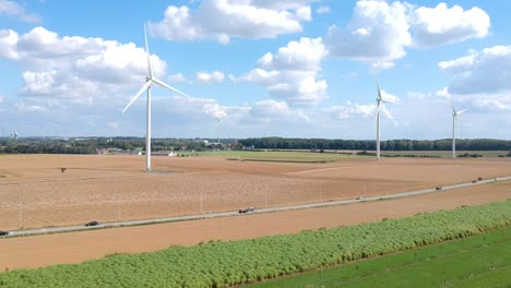 Drone-slowly-pans-over-a-wind-farm-next-to-a-freeway