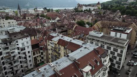 european building architecture in touristic old town, annecy city - aerial tilt-up reveal