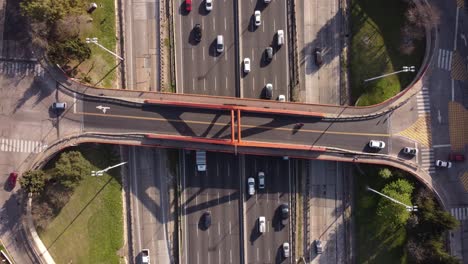 ascending top down shot of bridge crossing pan-american highway during rush hour time - connection between mexico and argentina