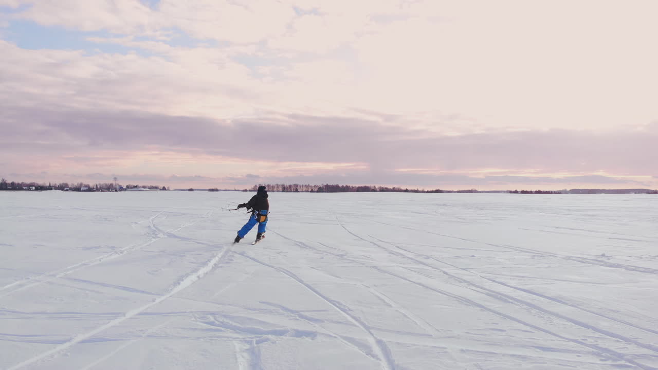 kitesurfista siendo arrastrado por su cometa a través de la nieve