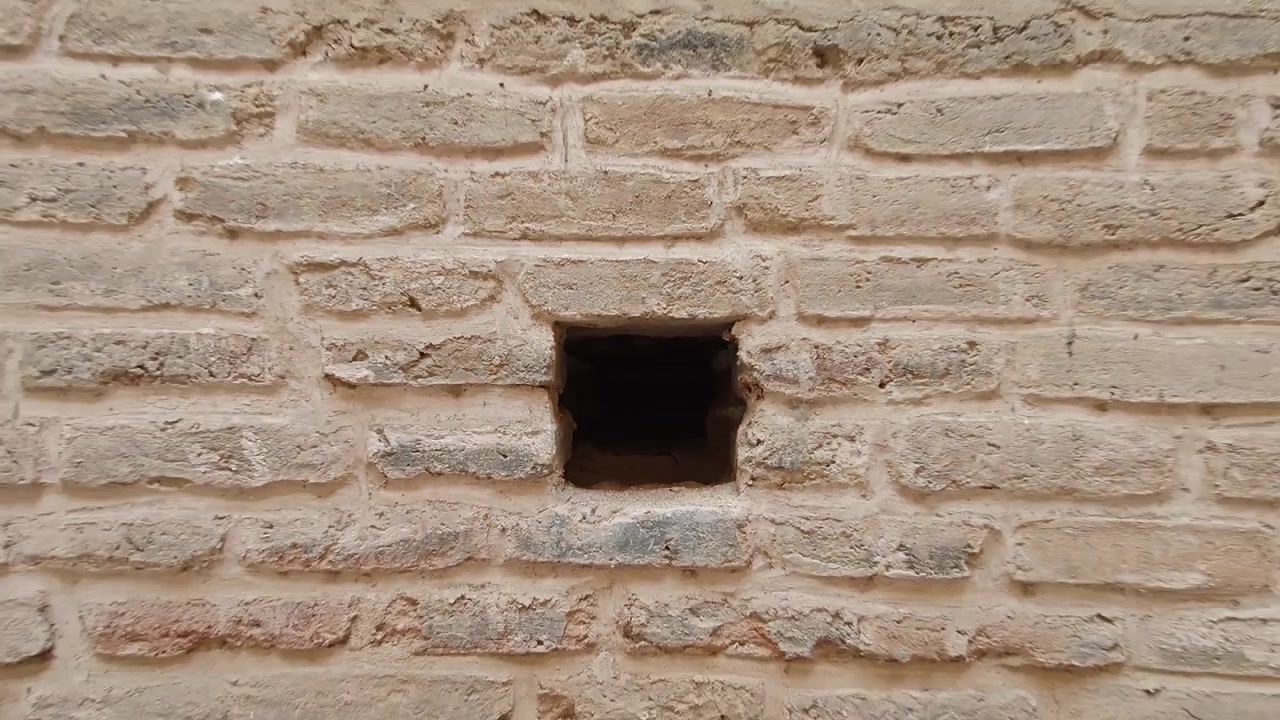 Close-up of a Small Square Opening in an Ancient Brick Wall