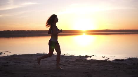 beauty runner woman running over sunset. young woman jogging along the sea coast. healthy lifestyle concept. slow motion