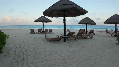 empty beach chairs and umbrellas at sunset