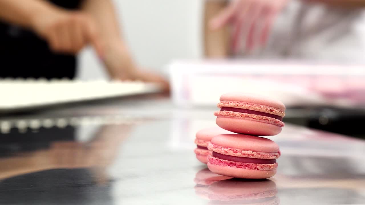 Delicious pink raspberry macaroons on the table at commercial kitchen