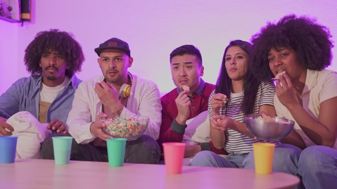 Diverse Group of Friends Enjoying a Movie Night with Snacks at Home