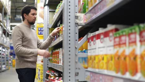 hombre comprando bebidas en una tienda de comestibles