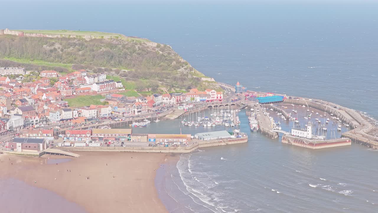 Porto di Scarborough, South Bay, North Yorkshire, Yorkshire e Humber, Inghilterra, Regno Unito, con la marina dei moli Est e Ovest, spiaggia e promontorio del castello, ripresa aerea statica con drone