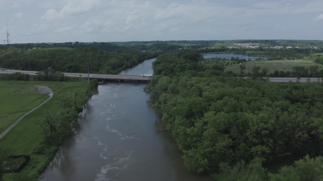 Drone flyver over en flod mod en ensom motorvej i Midtvesten i USA.