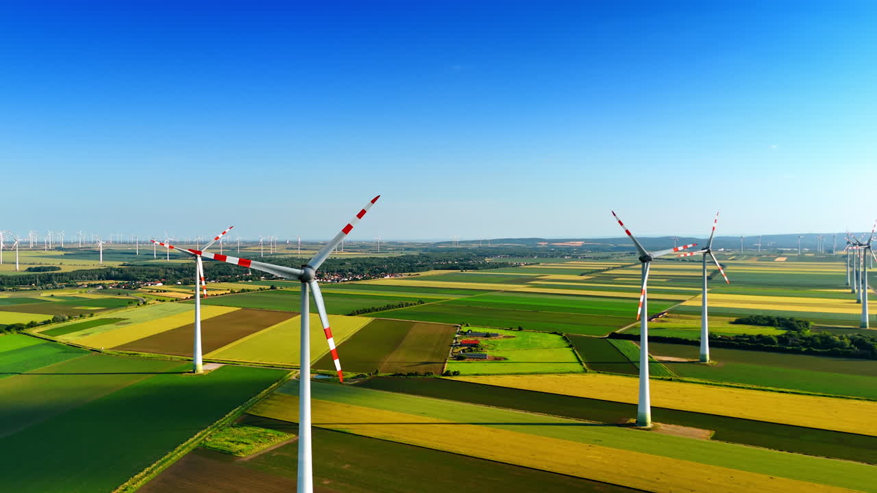 Wind turbines generating power. Wind turbines stand tall in a vibrant countryside landscape, harnessing renewable energy under a clear blue sky