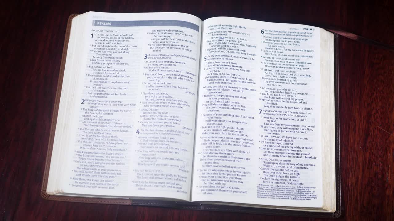 Otevírání hnědé Bible na knihu Žalmů na hnědém stole