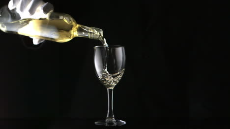 Gloved-hand-pouring-white-wine-into-glass