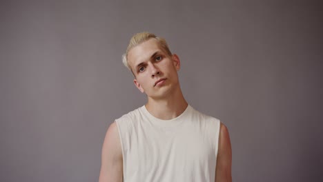 man with blonde hair and white tank top