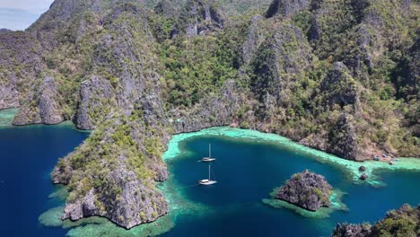 stunning scenic view of twin lagoon, turquoise waters, boats and hills at coron, philippines